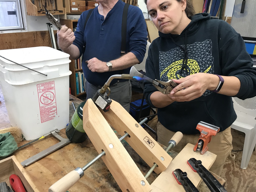 Students burn fitting a handle with a torch